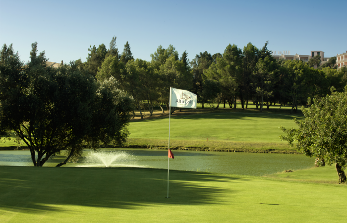 Green with flagstick and lake in front in the Alto Golf Course