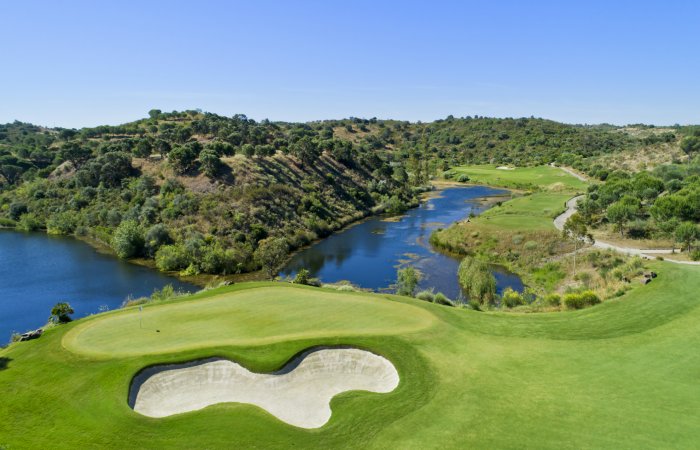 Green in the Monte Rei golf course with lake in front