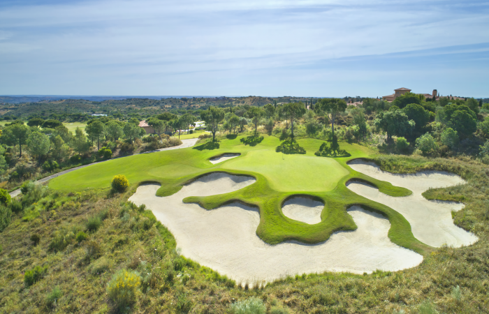 Green in the Monte Rei golf course surrounded by sand bunkers